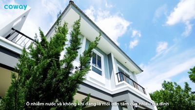 a white and gray house with trees in front of it