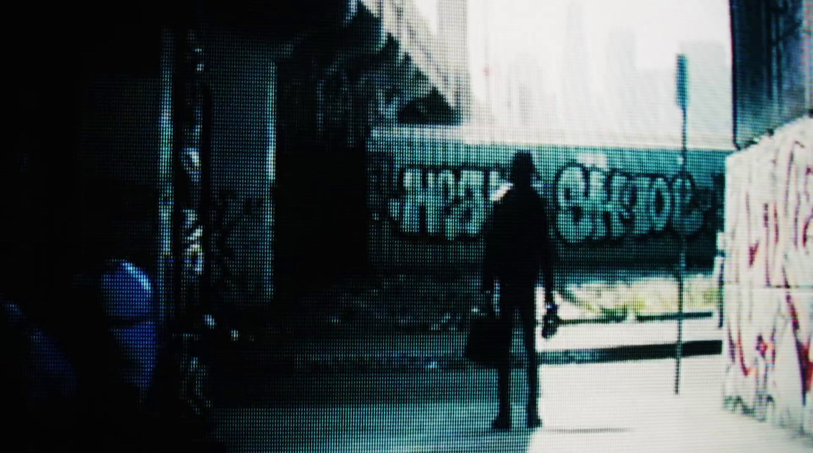 a man standing in front of a wall with graffiti on it