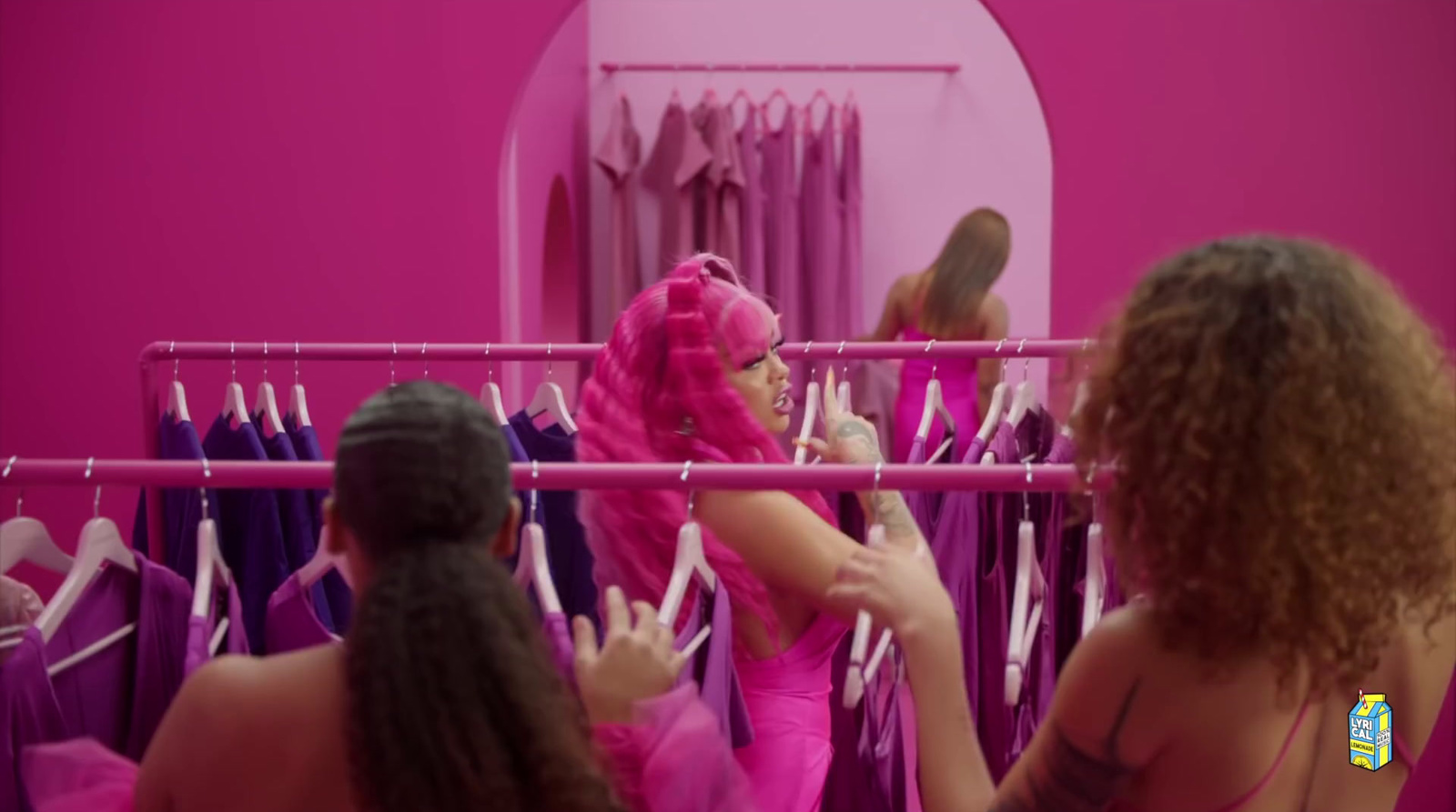 a group of women standing in front of a pink closet