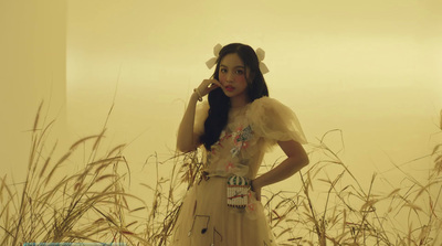 a woman standing in a field of tall grass