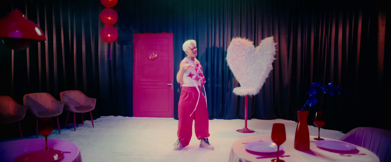 a woman standing in front of a pink door