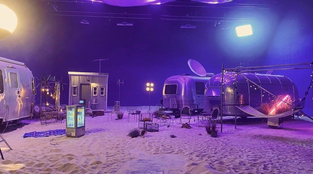 a couple of buses that are sitting in the sand