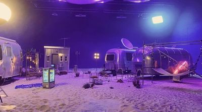 a couple of buses that are sitting in the sand