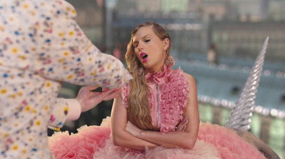 a woman in a pink dress sitting on top of a unicorn