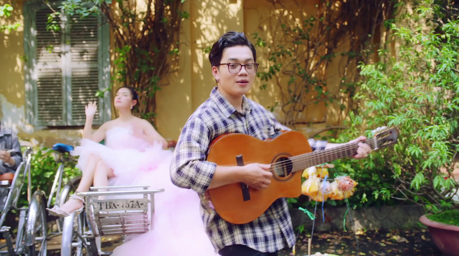 a man playing a guitar in front of a group of people