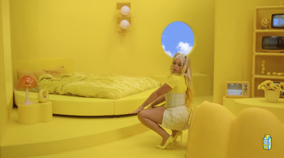 a woman sitting on a bed in a yellow room