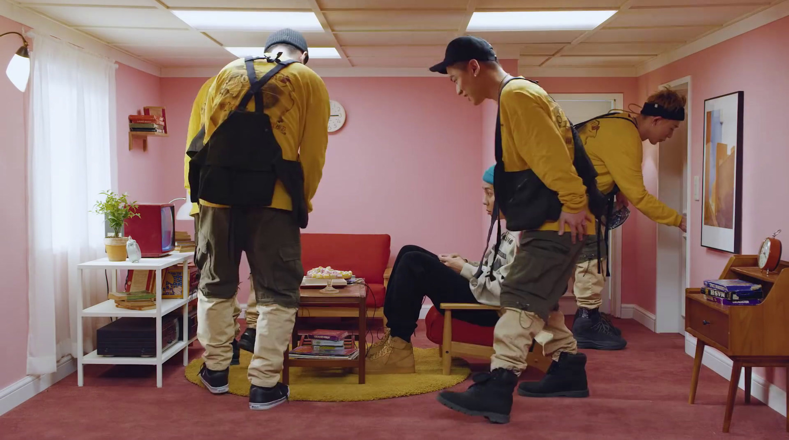 two men in yellow jackets are standing in a room