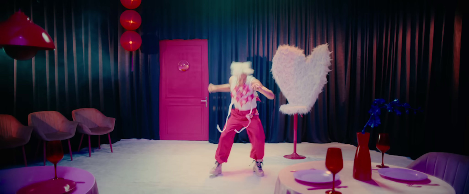 a woman dressed in pink dancing in a room