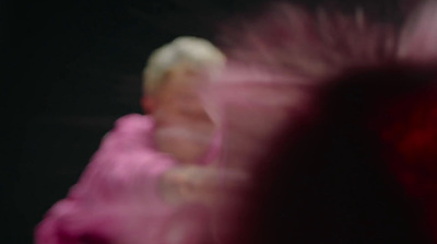 a blurry image of a woman in a pink dress