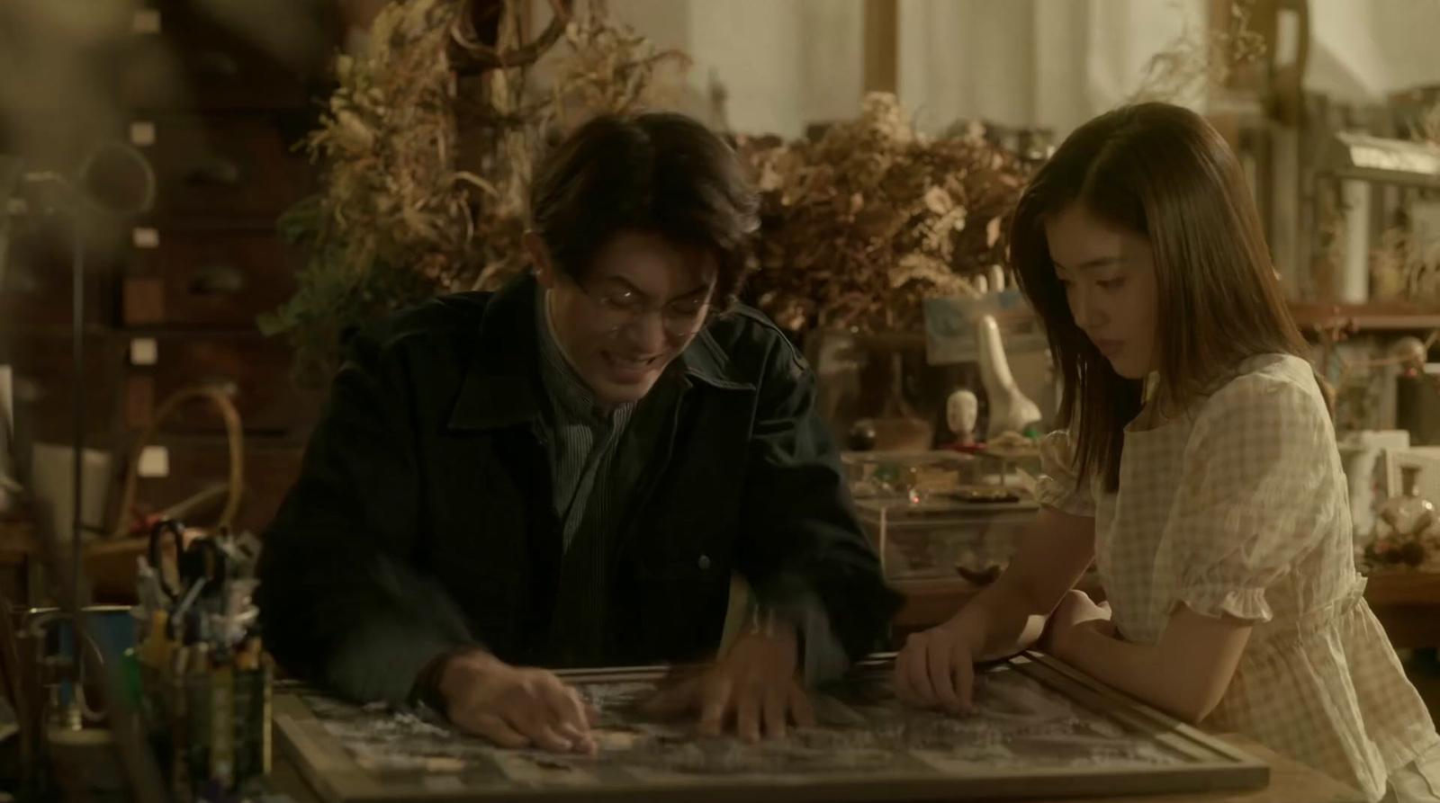 a man and a young girl looking at a puzzle
