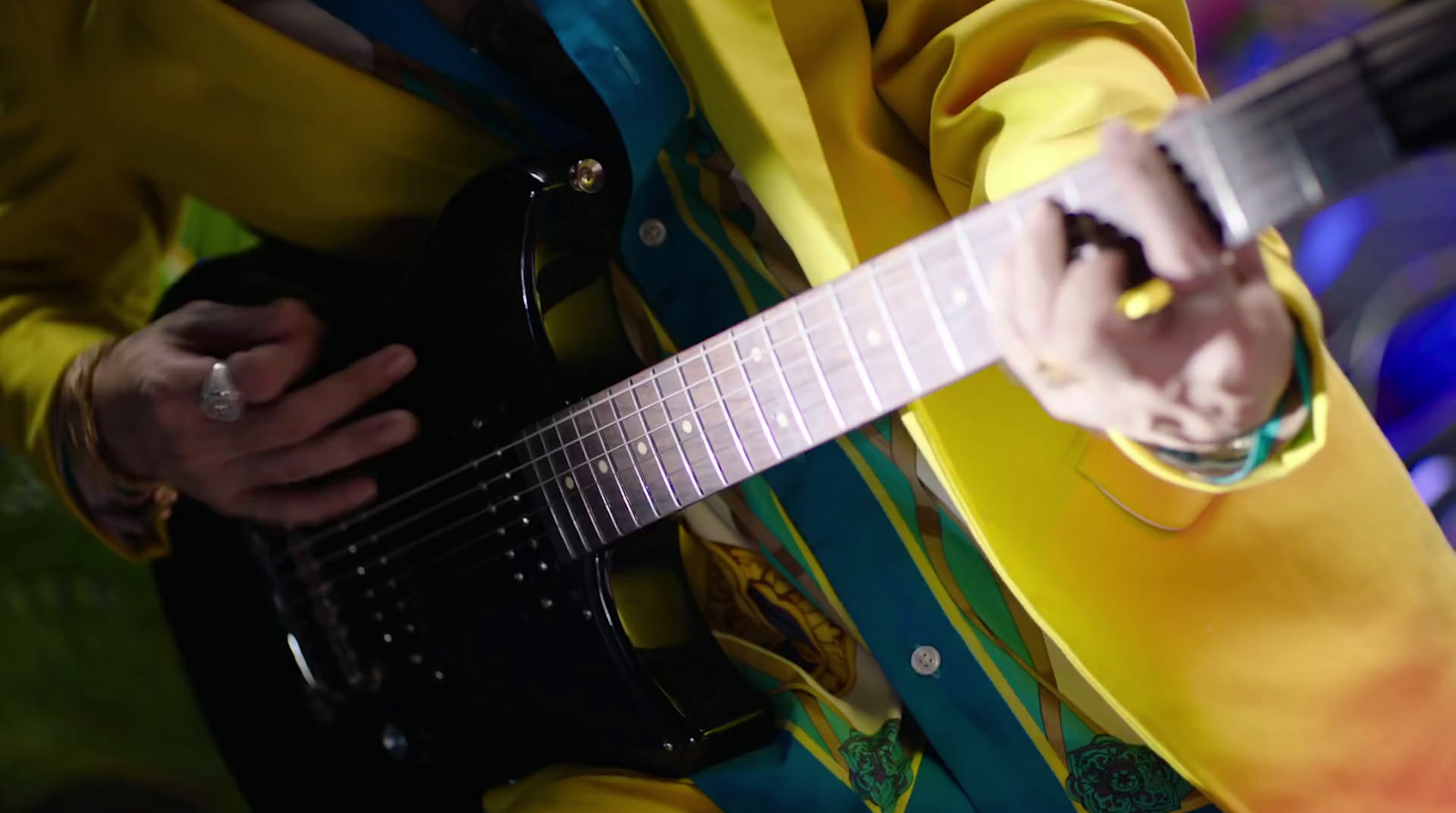 a man in a yellow suit playing a guitar