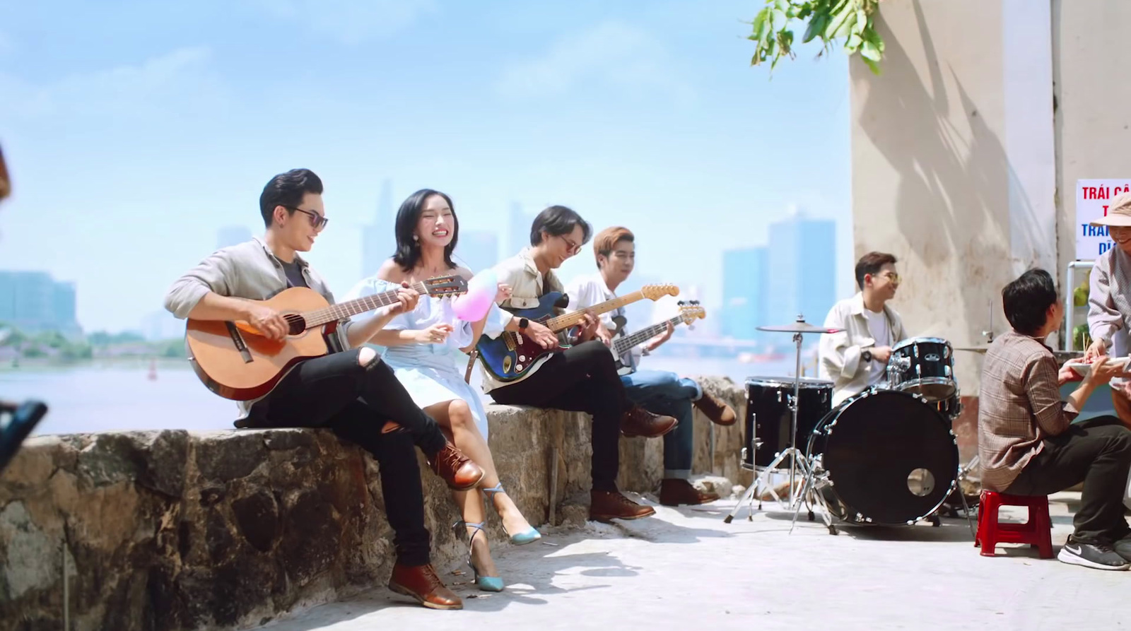 a group of people sitting next to each other playing guitars