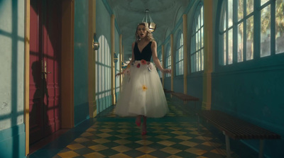 a woman in a dress walking down a hallway