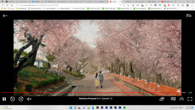 a couple of people walking down a street next to trees