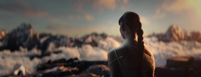 a woman standing in front of a mountain range