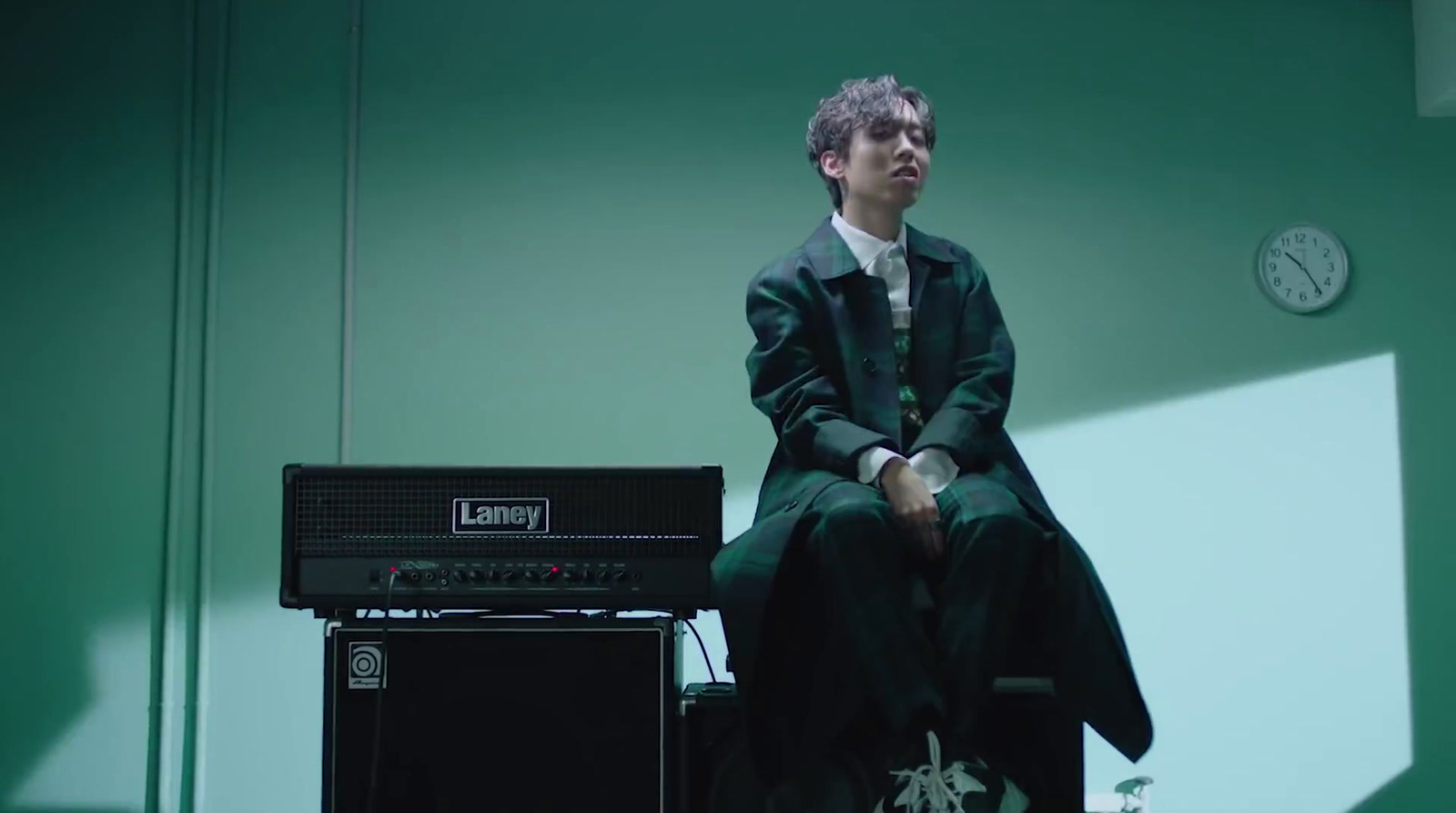 a man sitting on top of a chair next to a amp