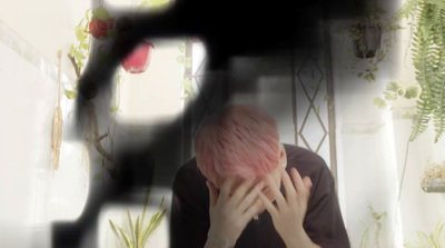 a person with pink hair sitting in front of a mirror