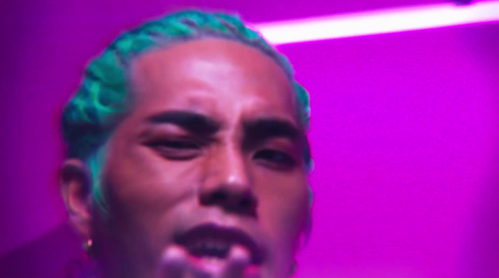 a man with green hair in a dark room