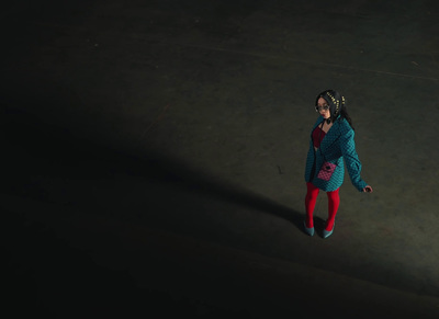 a little girl in a blue jacket and red tights