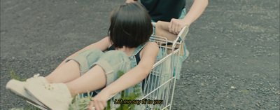 a couple of people sitting in a shopping cart