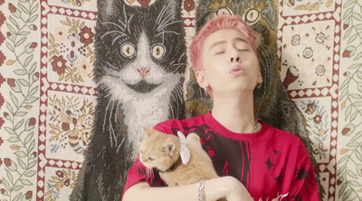 a man with pink hair holding a cat