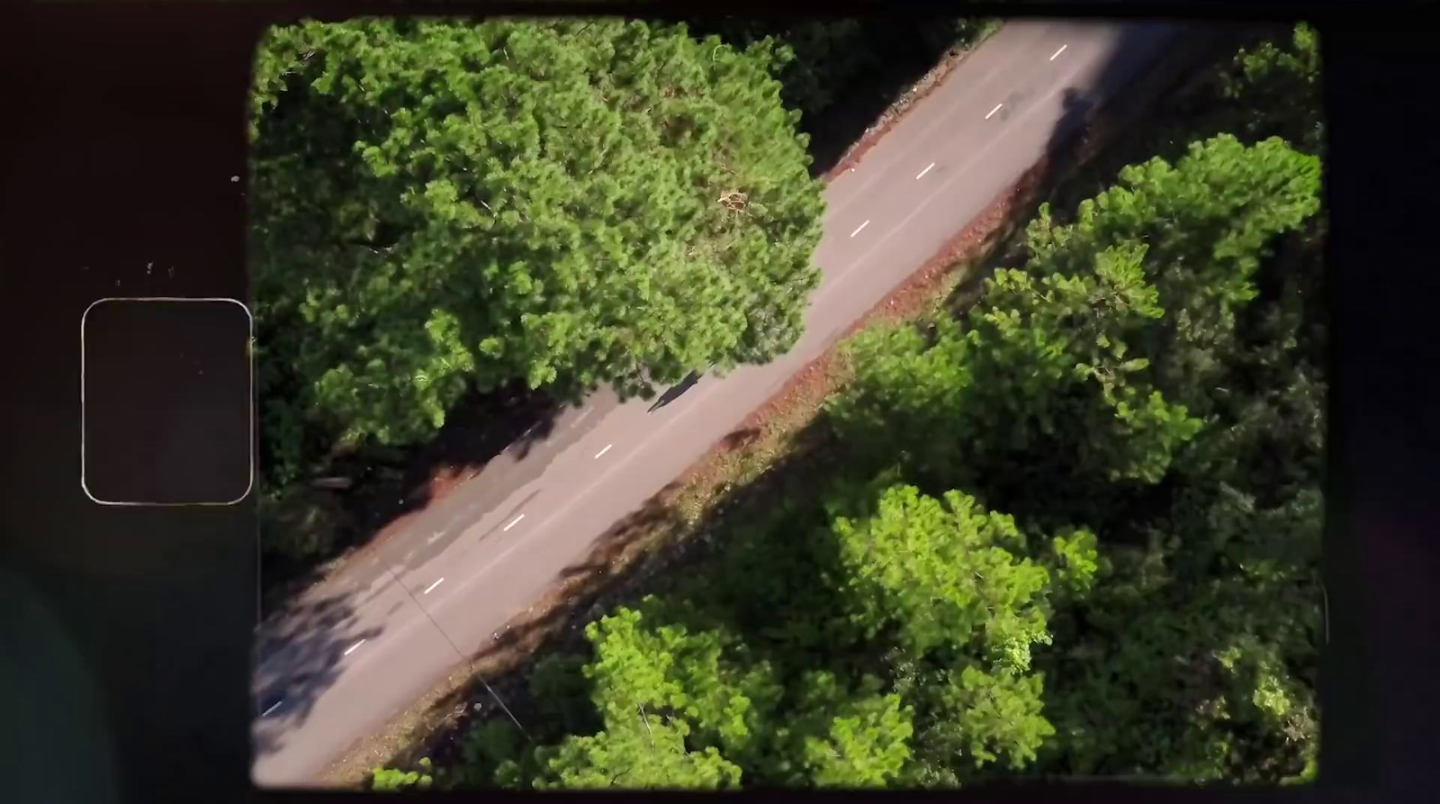 an aerial view of a road surrounded by trees