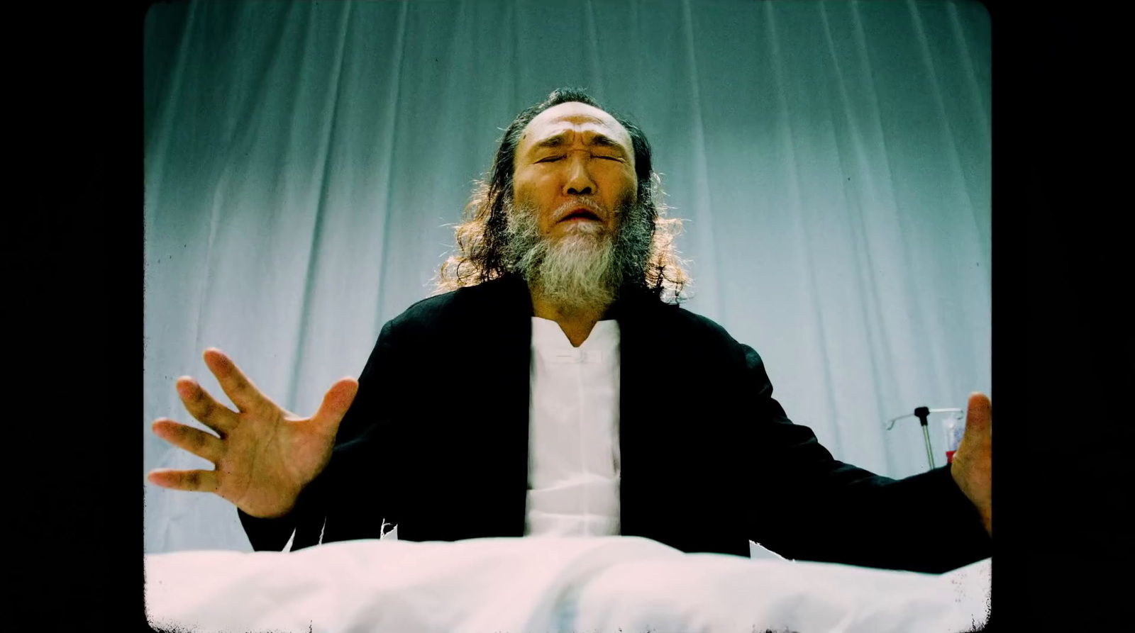 a man with long hair and a beard sitting in a chair