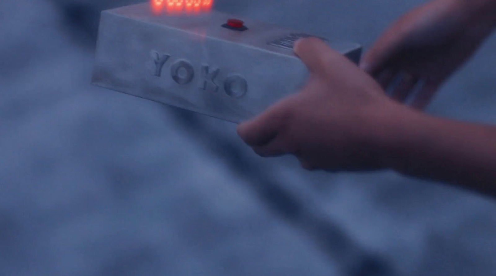 a person holding a small electronic device with a red light on it