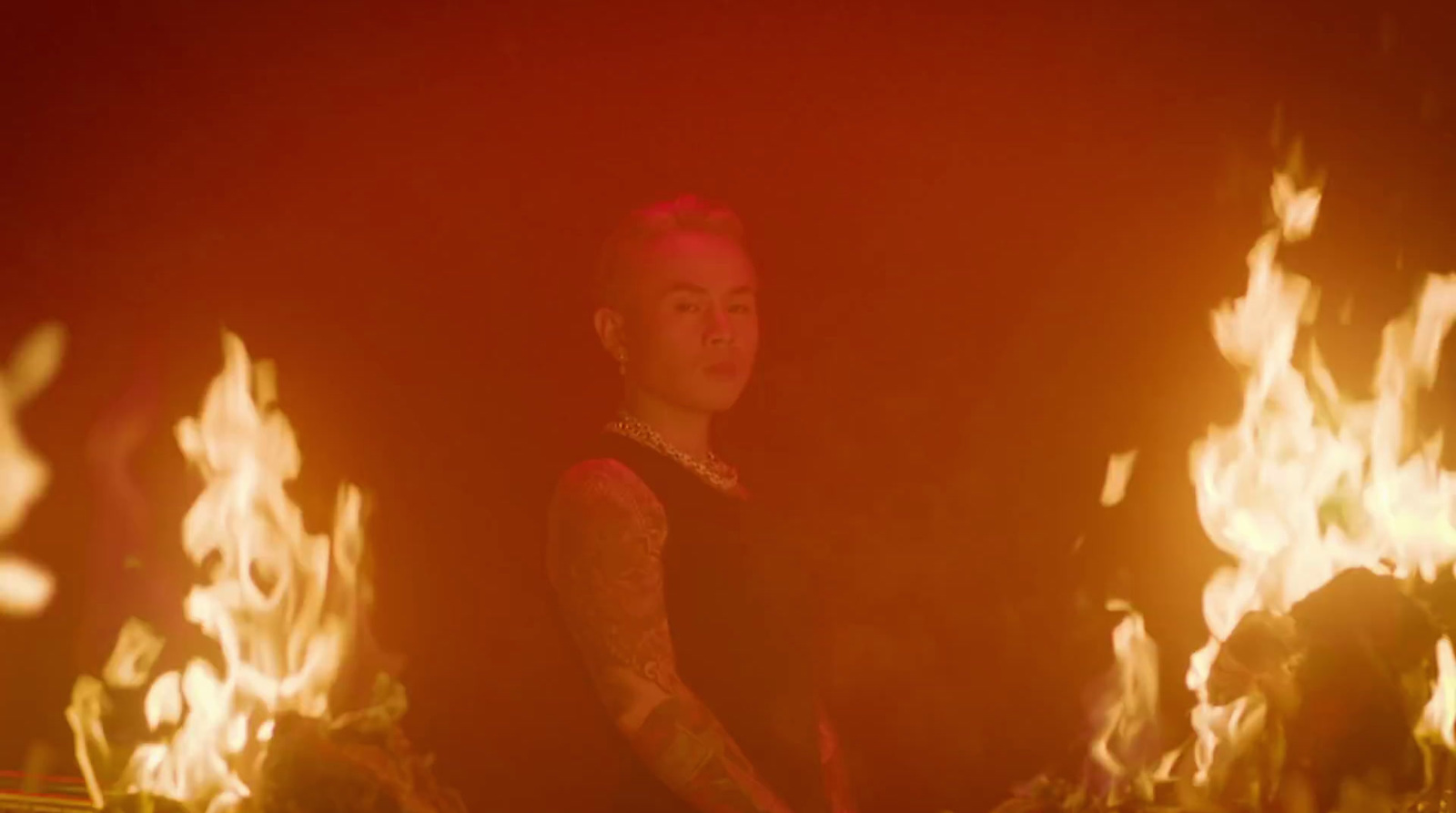 a woman standing in front of a bunch of fire