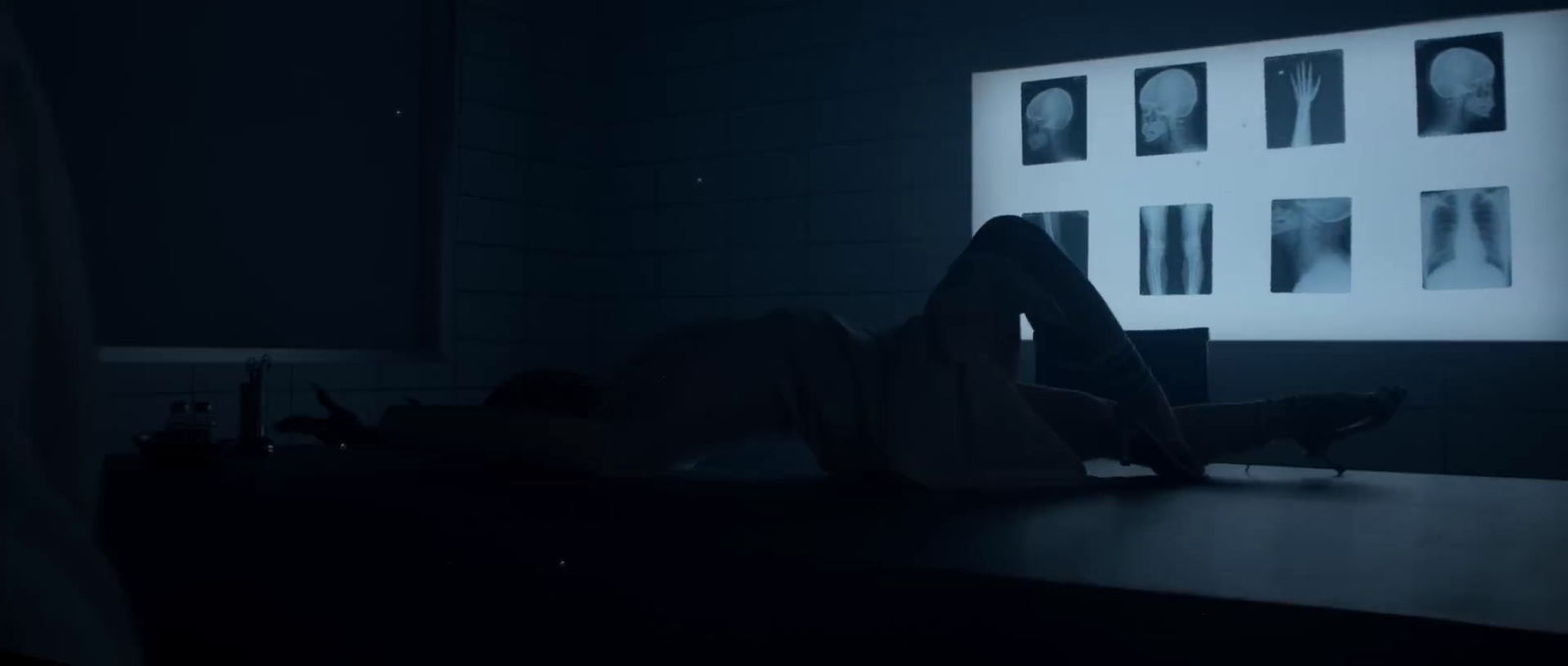 a person laying on a desk in a dark room