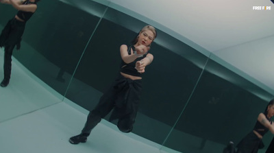 a woman in a black top is dancing in front of a mirror