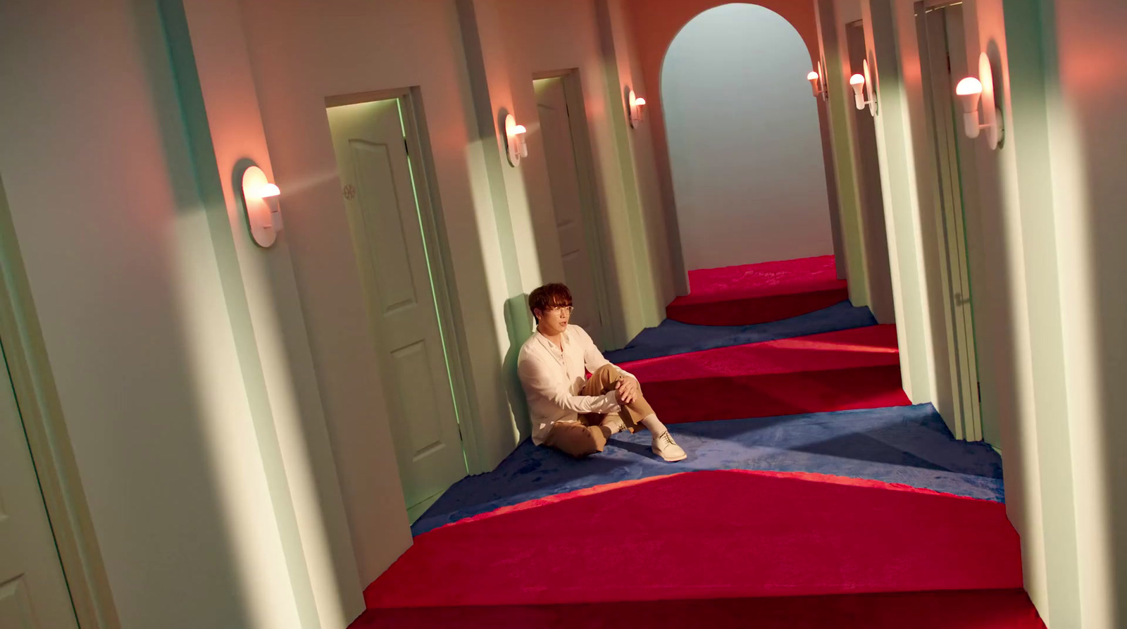 a person sitting on a red carpet in a hallway