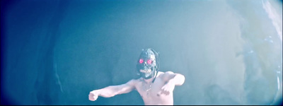 a shirtless man wearing a mask and holding a tennis racquet