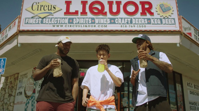 three men standing in front of a liquor store