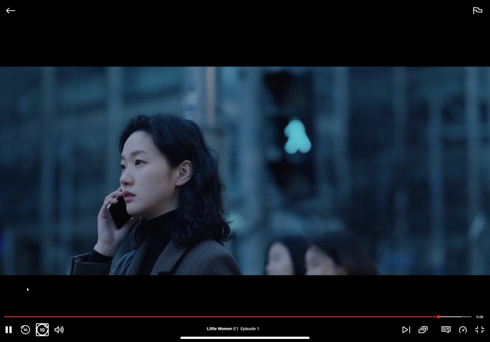 a woman talking on a cell phone next to a traffic light