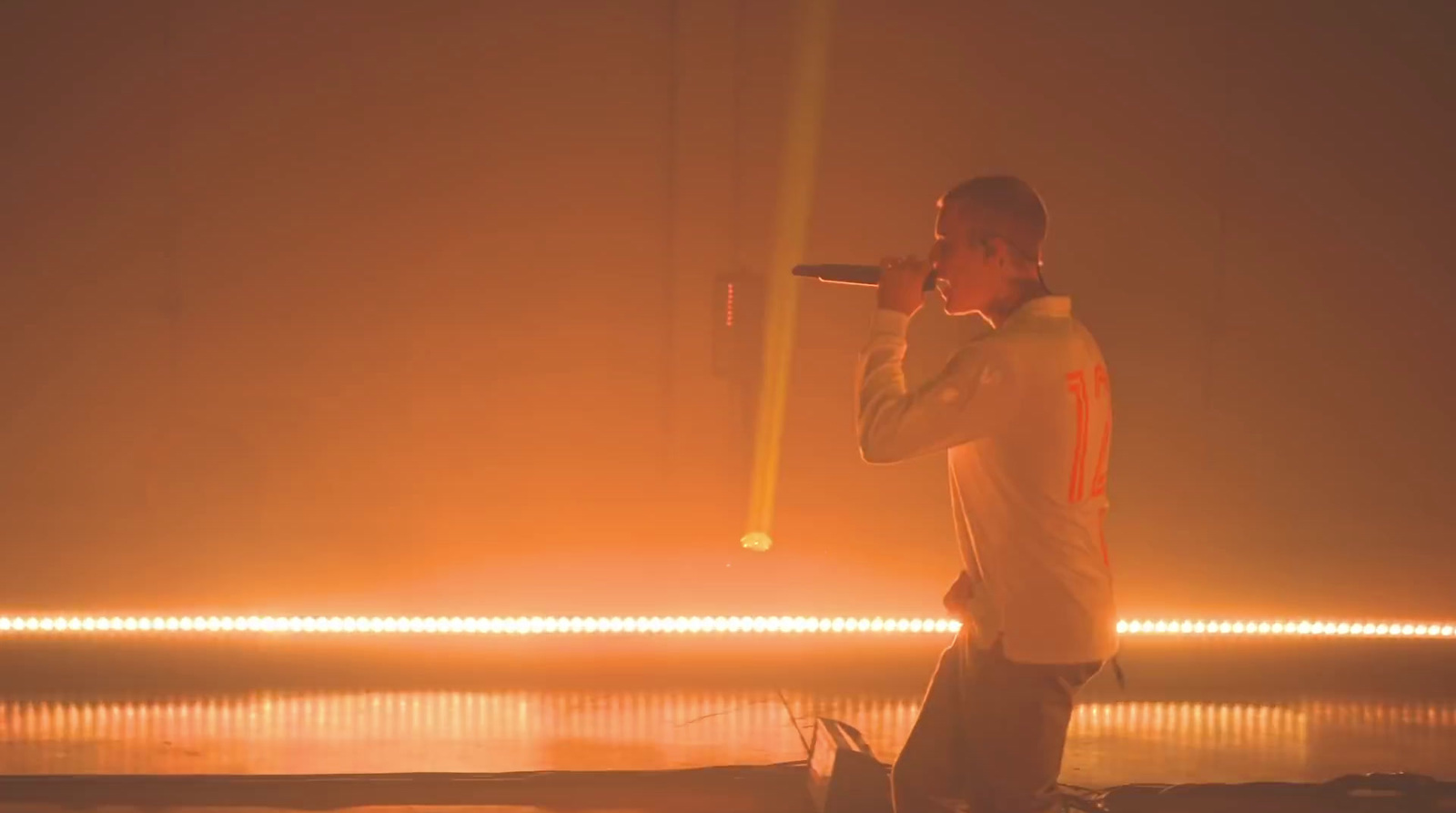 a man standing on a stage holding a microphone