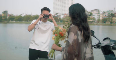 a man standing next to a woman holding a bouquet of flowers