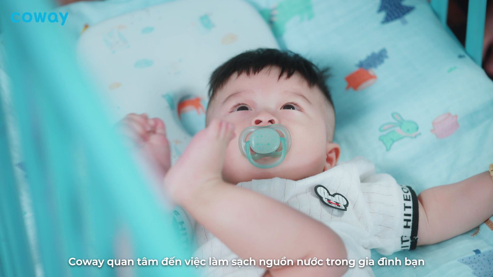 a baby laying in a crib with a pacifier in it's mouth