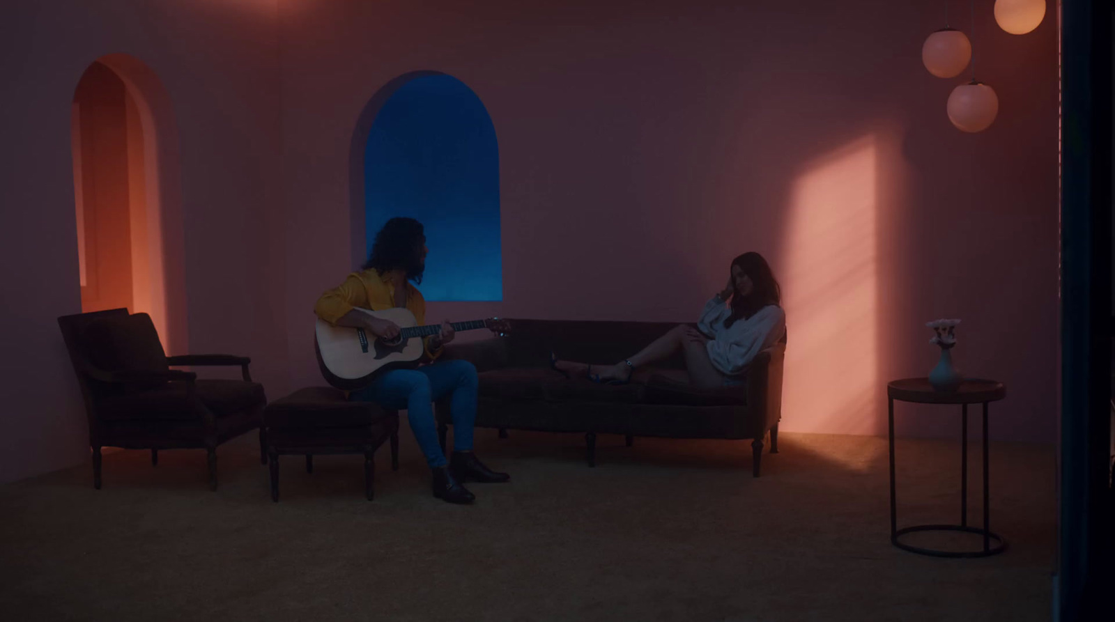 two women sitting on a couch playing guitars