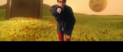 a man standing in a field of flowers holding a gun