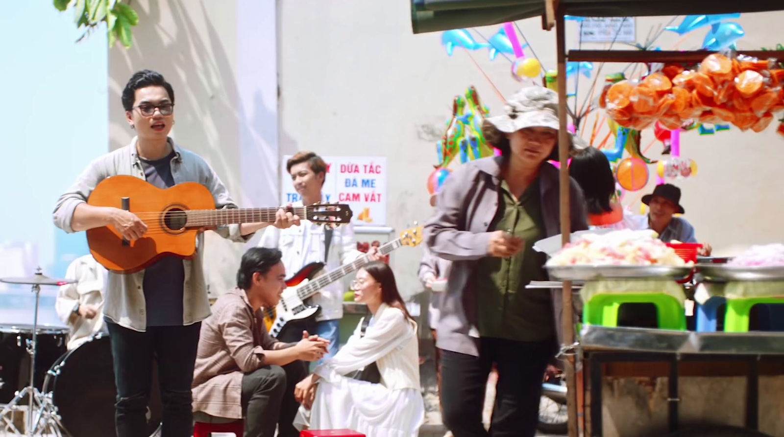 a man playing a guitar in front of a group of people