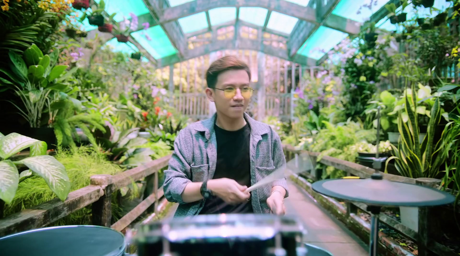 a man sitting in a greenhouse holding a knife