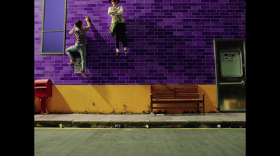 two people climbing up the side of a building