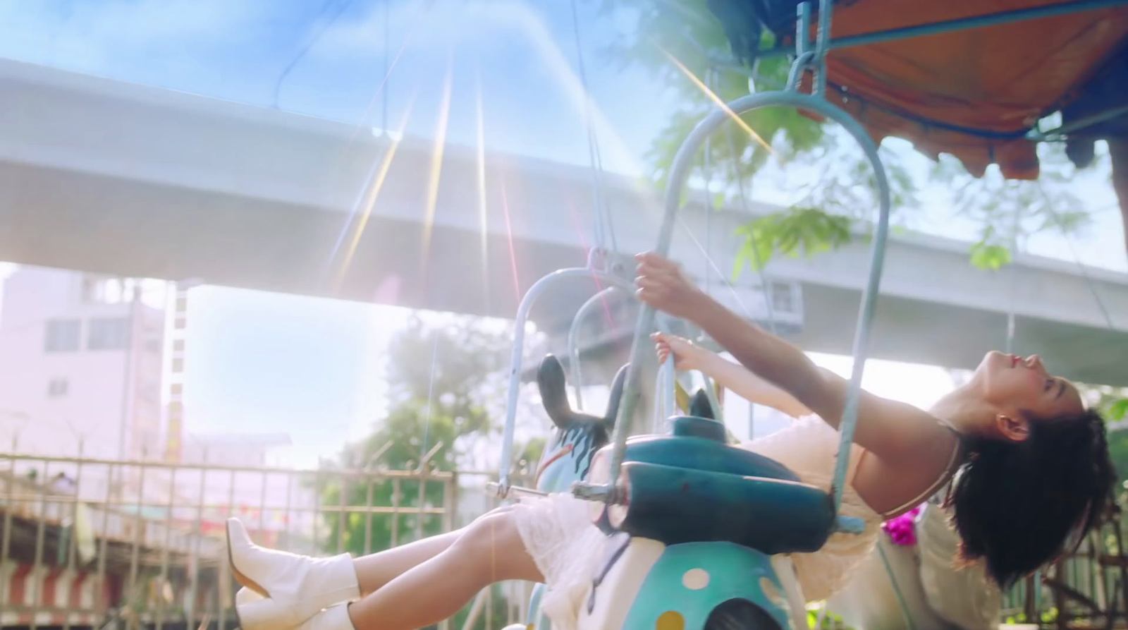 a woman is riding a swing ride in a park