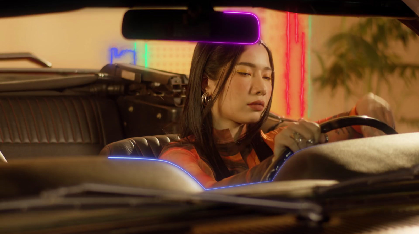 a woman sitting in a car holding a steering wheel