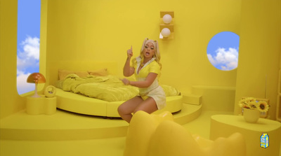 a woman sitting on a bed in a yellow room