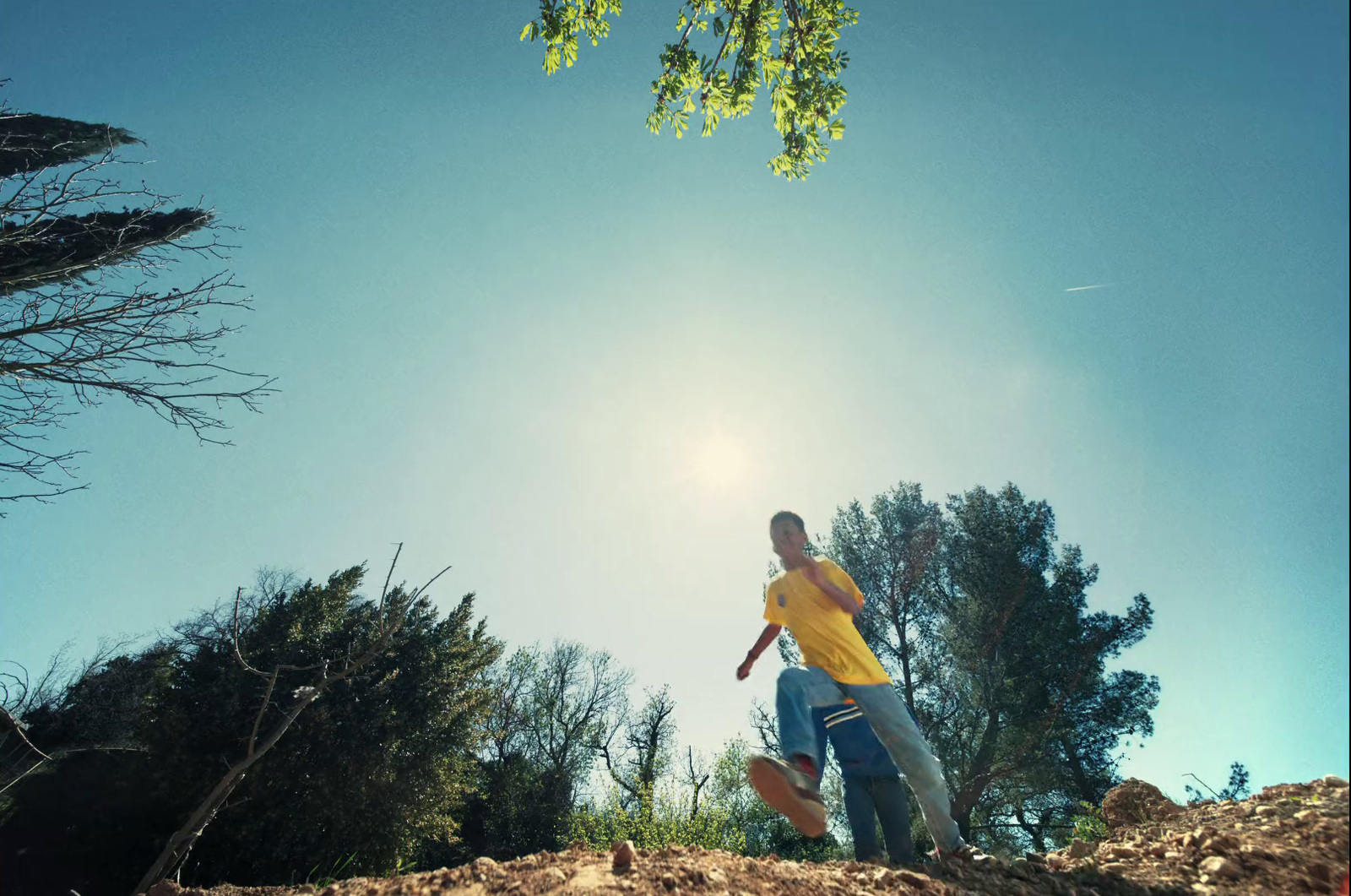 a man in a yellow shirt holding a skateboard