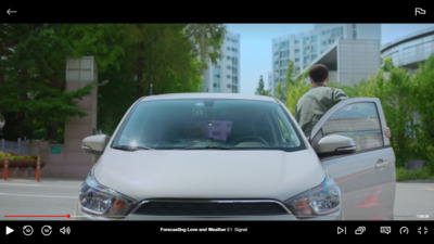 a white car driving down a street next to a man