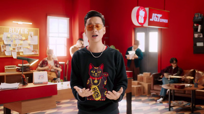 a man in a red room with a black cat sweater