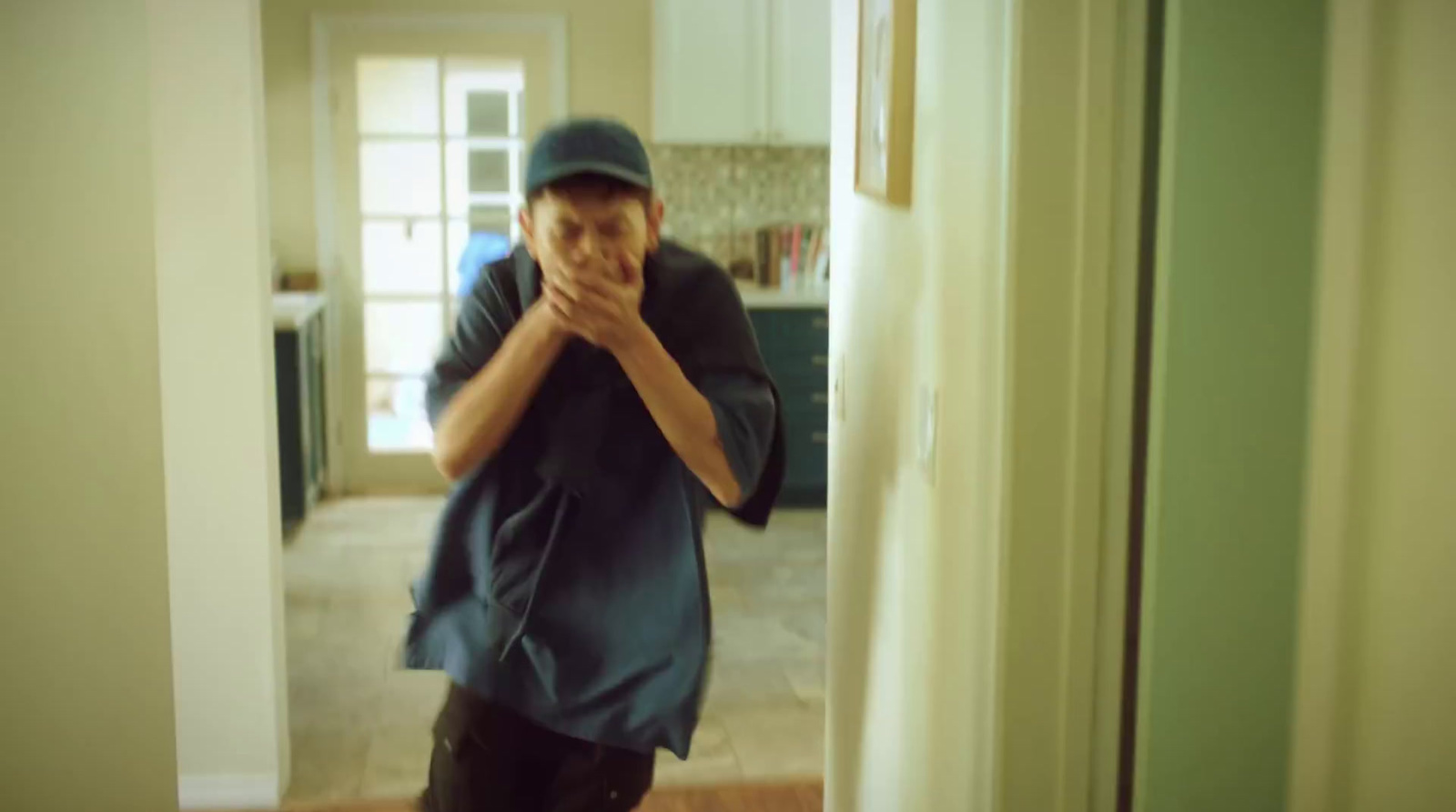 a man standing in a kitchen next to a doorway